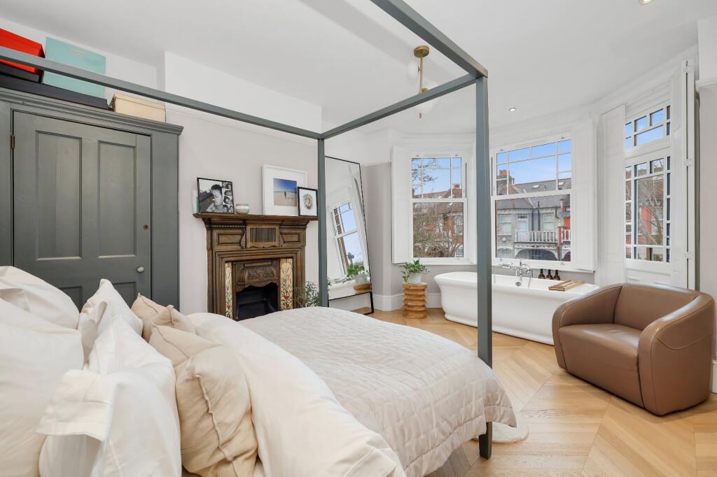 Main bedroom with four poster bed and period fireplace